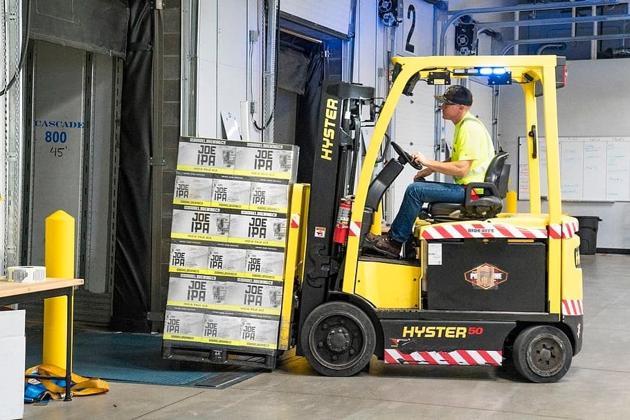 A man is lifting heavy blocks using used forklifts
