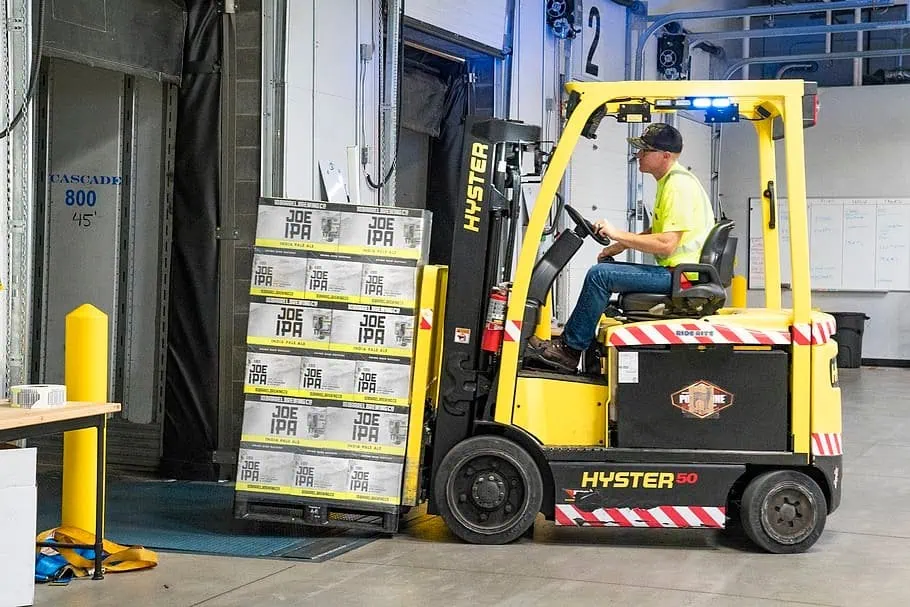 A man is lifting heavy blocks using used forklifts